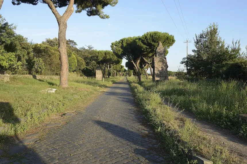 Basolato romano della Via Appia Antica fiancheggiato da pini e cipressi